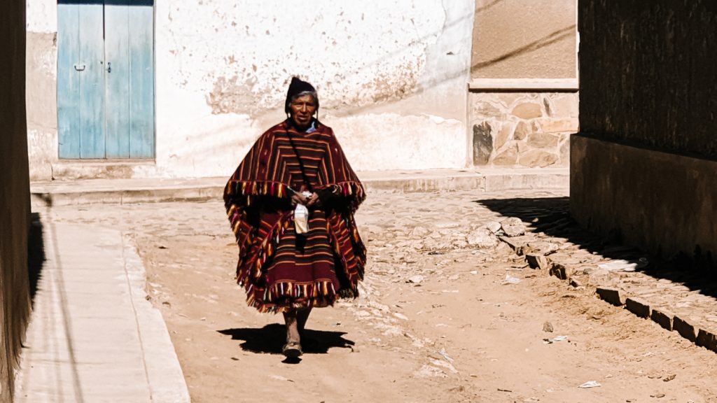 De mannen in Tarabuco dragen vaak zwarte helmachtige hoofddeksels met versiersels en gestreepte poncho’s.