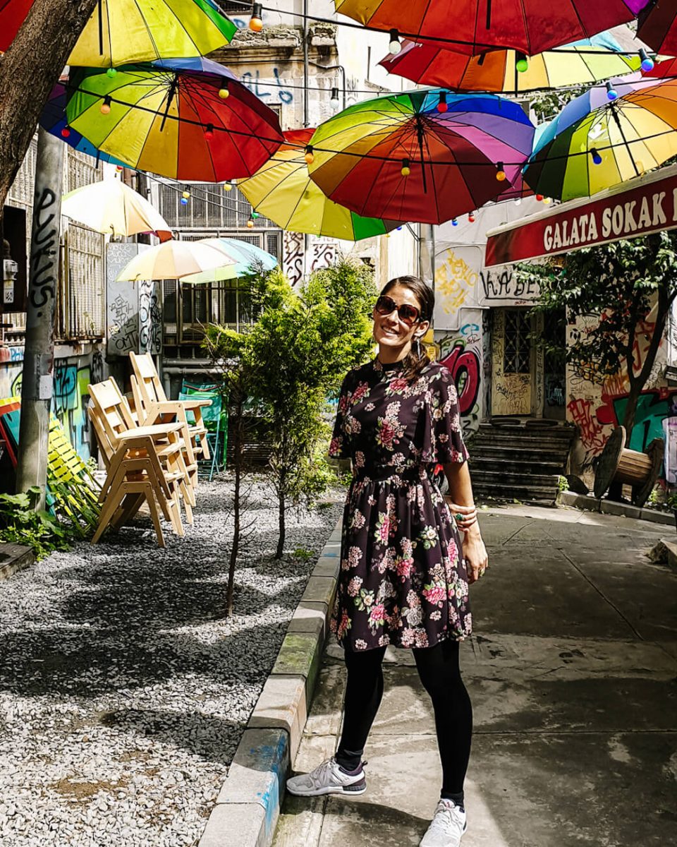 Deborah in kleurrijk straatje met parasols in Istanbul