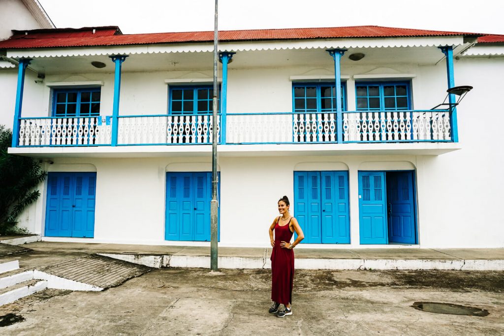 vrouw voor gekleurde huisjes in Flores