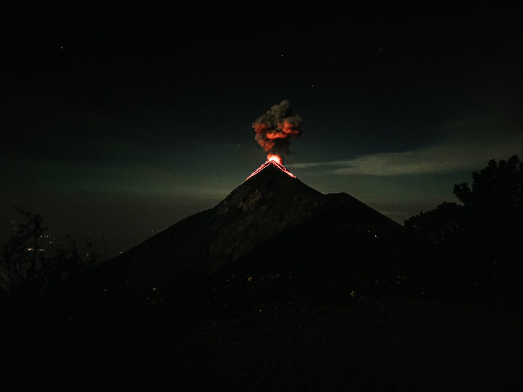 the erupting Fuego volcano with smoke and red lava 