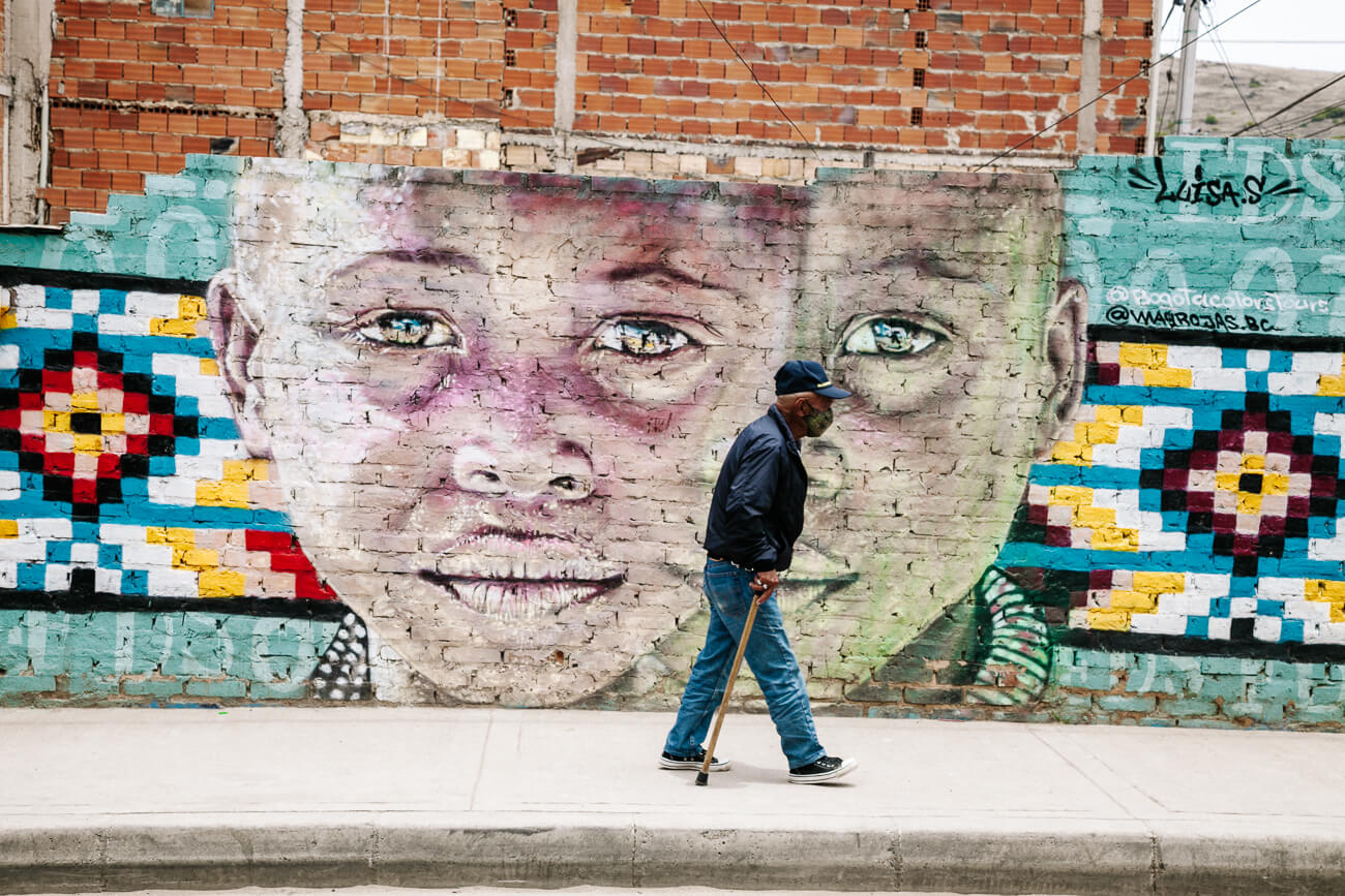 Local people in front of mural, a street art tour in Ciudad Bolivar is among the best things to do in Bogota Colombia