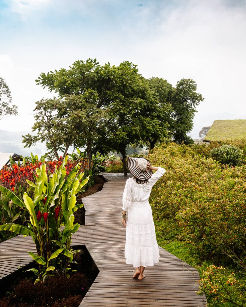 Deborah on trail surrounded by greenery and flowers in El nido del condor ecolodge