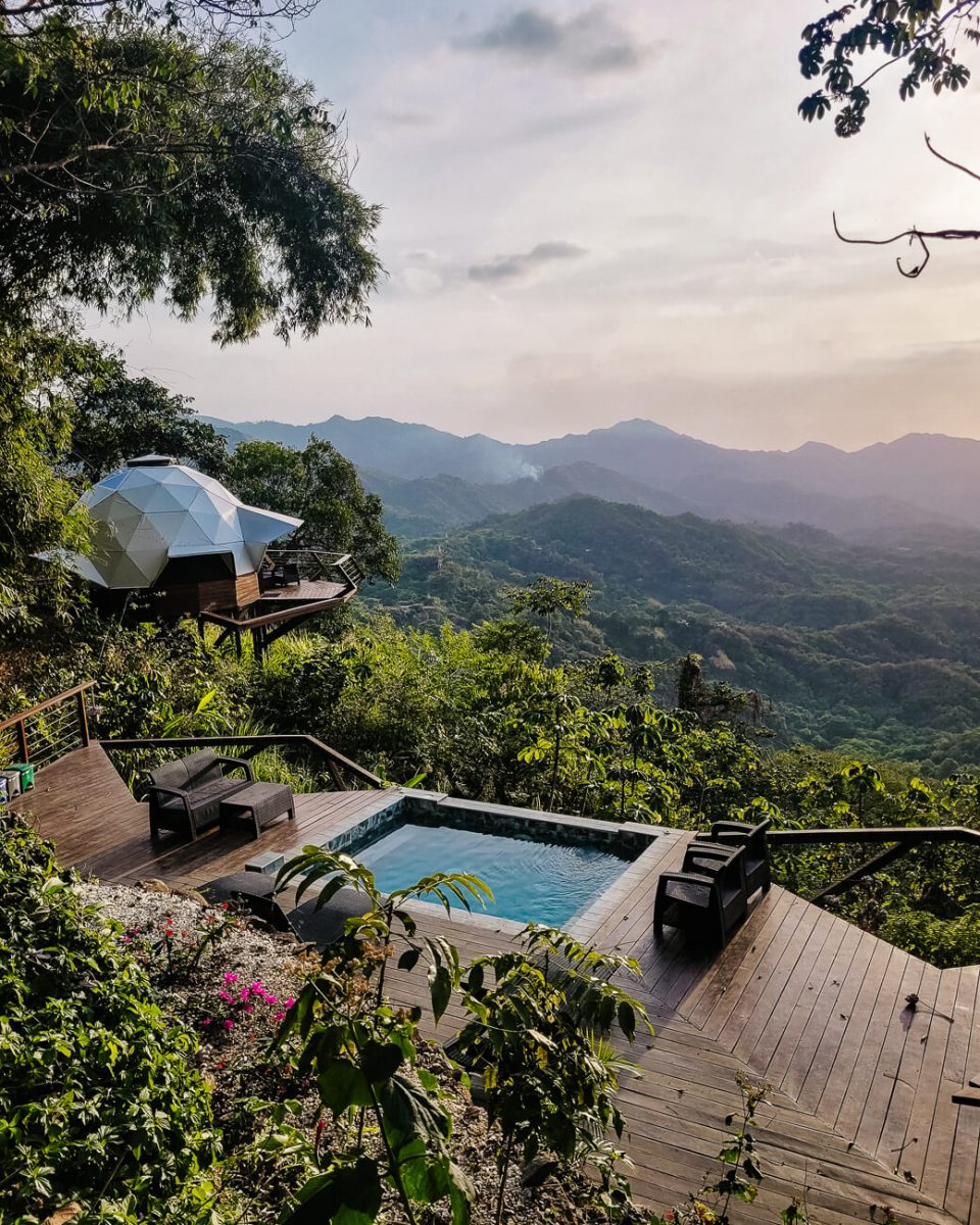 uitzicht op groene jungle, jacuzzi en domes vanaf Trekker Glamping Minca in Colombia