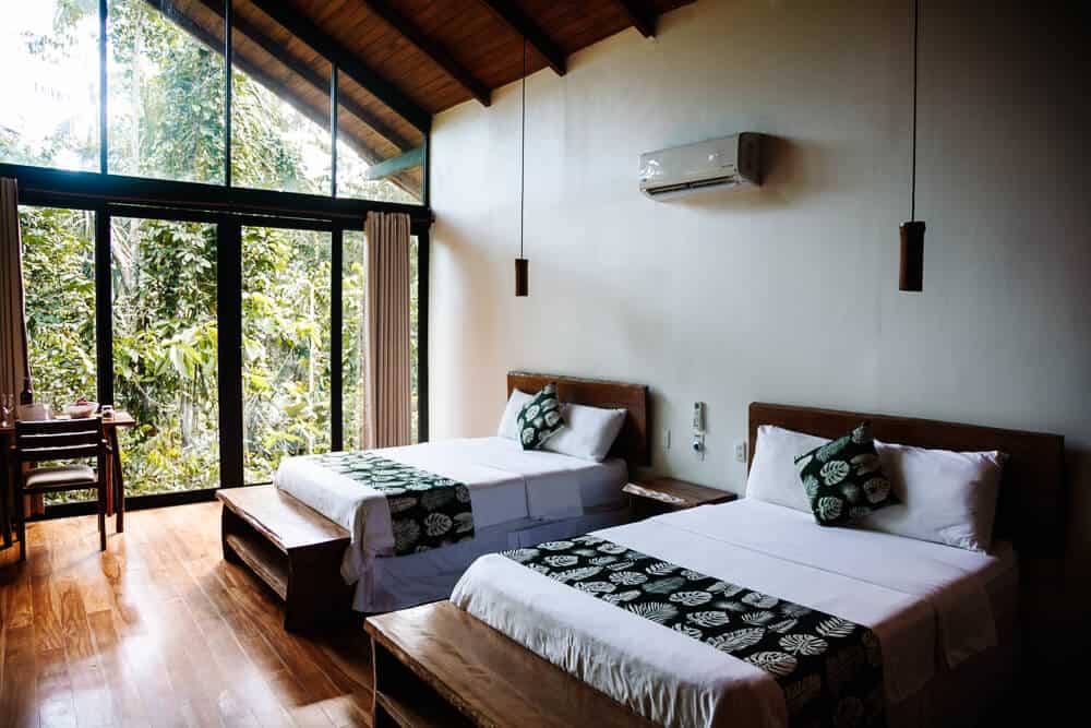 De kamers van Sacha Lodge in Ecuador zijn van natuurlijke materialen gemaakt, hoog, ruim en modern ingericht met overal glas. 