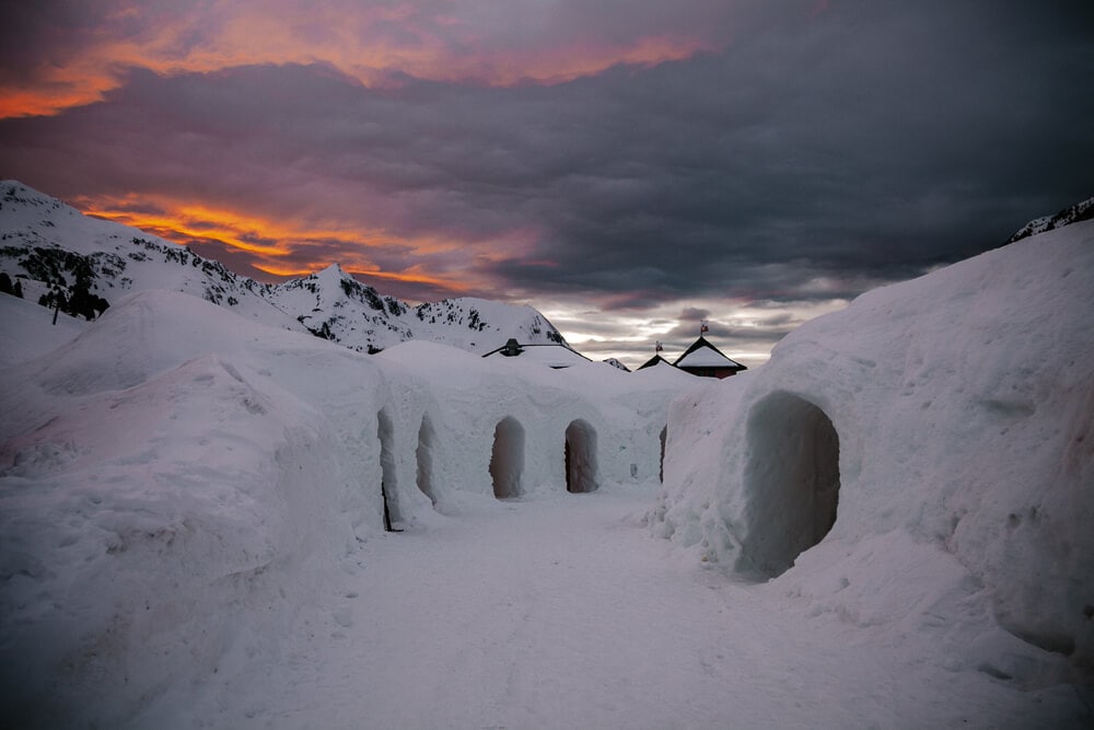 Iglu-Dorf Innsbruck Kühtai, het iglo hotel in Oostenrijk tijdens zonsondergang.