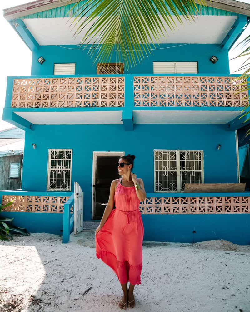 Deborah vóór Caribisch gekleurd huisje.