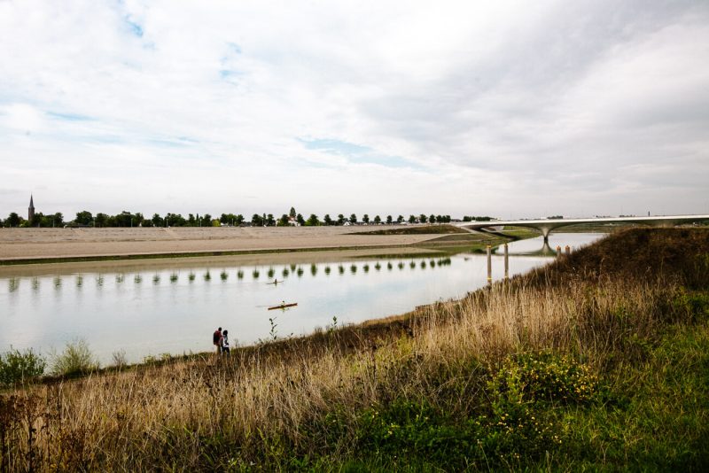 Uitzicht van Stadseiland Veur-Lent. Via de snelbinder of Waalbrug, loop je vanuit het oude centrum van Nijmegen zo naar stadseiland Veur-Lent. Een plekje waar je kunt wandelen, suppen of bij mooi weer relaxen op het strandje. Bovendien heb je hier beste uitzicht op het centrum en maak je mooie foto’s. 