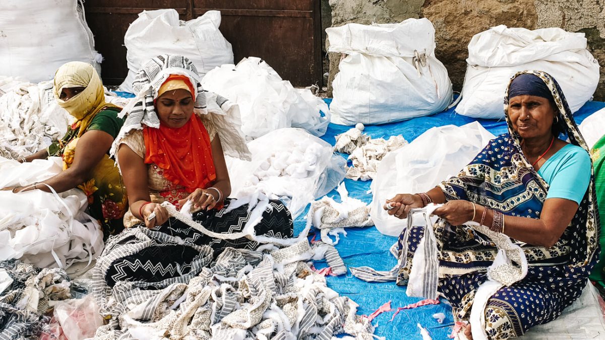 In the clothing recycling street there are several small businesses, each responsible for large piles of used clothing.