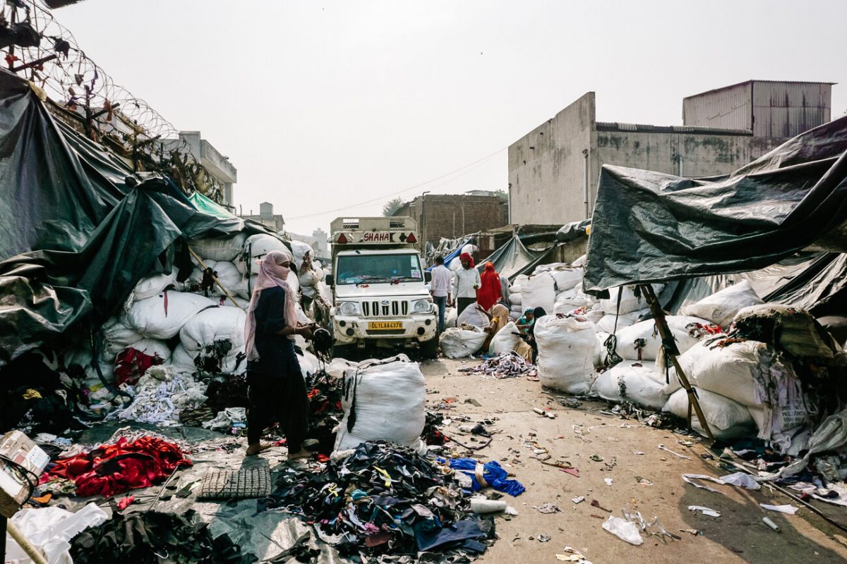 In the clothing recycling street there are several small businesses, each responsible for large piles of used clothing.